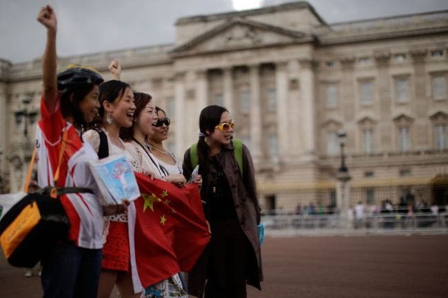 Chinese tourists have their pictures taken outside Buckingham Pa