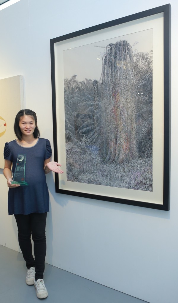 Tiong Chai Heing bergambar bersama karya seninya yang diberi nama Stifling serta trofi kemenangan. beliau juga berjaya membawa pulang hadiah utama kategori pelukis mapan iaitu wang tunai sebanyak AS$25,000.