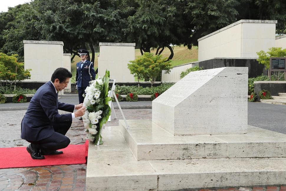 Abe meletakkan kalungan bunga di tugu peringatan peperangan. Foto - US NEWS